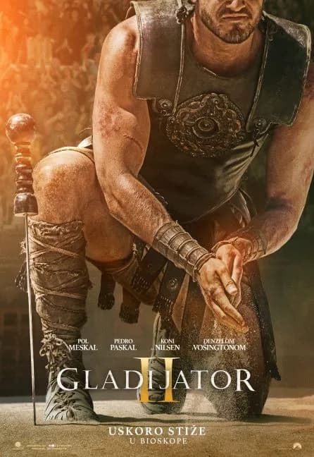 Plakat filma Gladijator II: klečeći ratnik u oklopu trlja pesak među rukama, mač zabijen pored njega